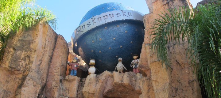 Foto de um globo no alto de uma parede de pedra com alguns bichinhos de animação na entrada da atração turística Raskapuska do parque de diversões Beto Carrero World